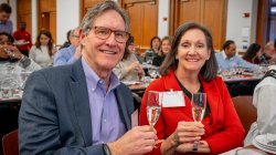A man and woman holding glasses smiling.